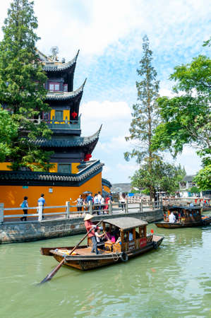 Shanghai, China - September 2019: Tourist sightseeing boat cruising pass Yuanjin Temple in Zhujiajiao Ancient Water Town, a historic village and famous tourist destination in Qingpu District of Shanghai, Chinaのeditorial素材