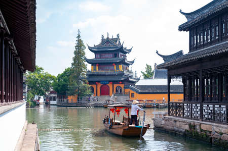 Shanghai, China - September 2019: Tourist sightseeing boat cruising pass Yuanjin Temple in Zhujiajiao Ancient Water Town, a historic village and famous tourist destination in Qingpu District of Shanghai, Chinaのeditorial素材