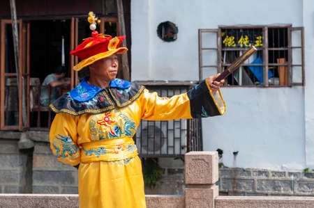 Shanghai, China - September 2019: A male street performer in Chinese traditional costume performing at Zhujiajiao Ancient Water Town, a historic village and famous tourist destination in Shanghai, Chinaのeditorial素材