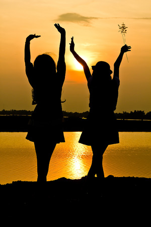 The silhouette of two girl people.の写真素材