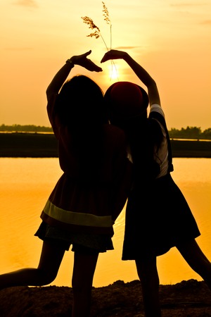The silhouette of two girl people. In Thailand.の写真素材