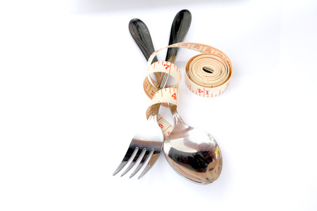 Empty plate with a spoon, fork and measuring tape