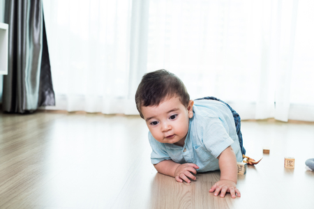 crawling funny baby boy indoors at homeの写真素材