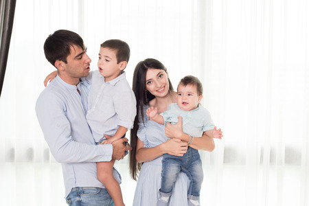 Mother and father holds on a hands their little children