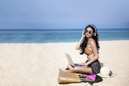 woman relax in vacation using laptop computer on the beach. Freelance work concepの写真素材