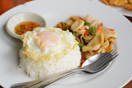 Steamed rice Fried basil leaves with mixed seafood and topped with fried eggの写真素材