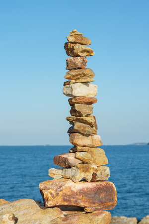 Stack of stones balance over blue sea and blue sky in the eveningの写真素材