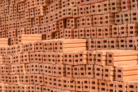 Stack of red clay bricks wall buildingの写真素材