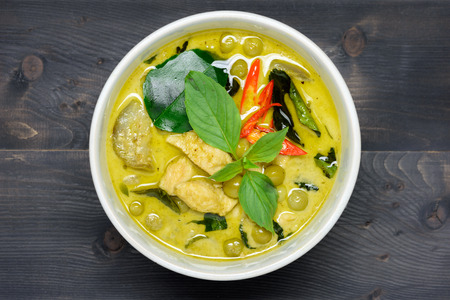 green curry with chicken (Kang Keaw Wan Gai) on wooden background top view, Thai local foodの写真素材