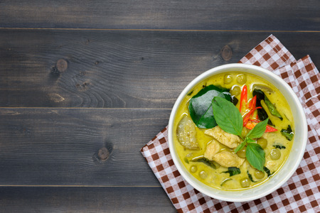 green curry with chicken (Kang Keaw Wan Gai) with brown tablecloth on wooden background top view, Thai local foodの写真素材