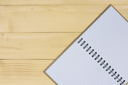 Brown notebook made from recycled open blank book pages on wooden background with copy spaceの写真素材