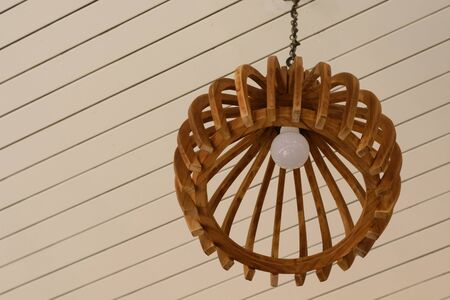 Wooden electronic lamp hanging from the ceilingの写真素材