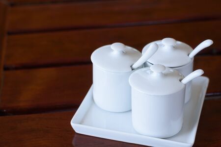 white cup of seasoning on wooden tableの写真素材