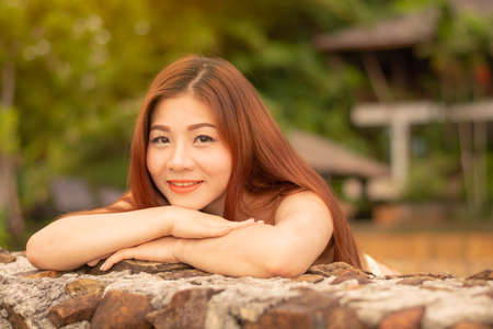 Asian woman standing, smiling and looking in the eye.の写真素材