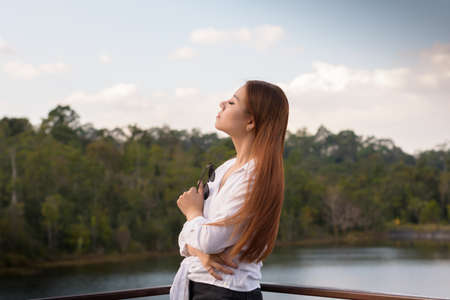 Portrait asian woman standing and relaxing in the forest