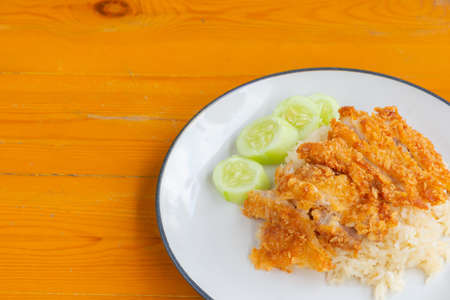 Closeup of Chicken rice with cucumber on the wooden tableの写真素材