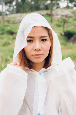 close up woman wear raincoat stand in the rainforestの写真素材