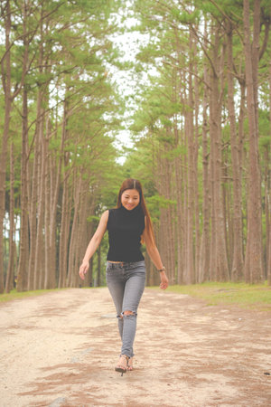 Portrait asian woman walking and relaxing in the pine forestの写真素材
