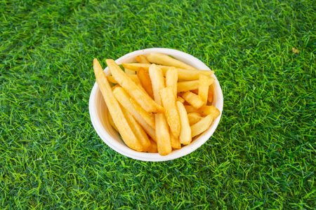 French fries yellow on green grass, top view close up.の写真素材