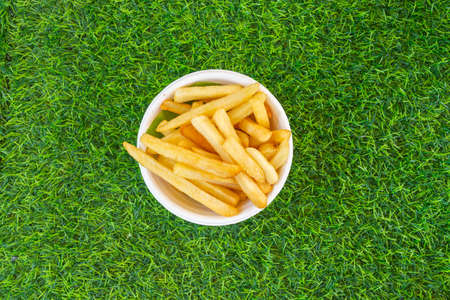 French fries yellow on green grass, top view close up.の写真素材