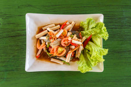 Lotus Stem Thai Spicy Salad on a green table, Thai local food.の写真素材