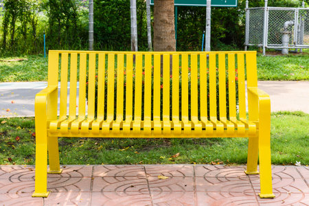 Colored yellow bench in a park outdoor gardenの写真素材