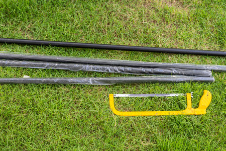 A yellow hacksaw on the green lawnの写真素材