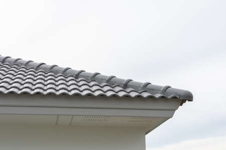 Gray top roofing residential home with skyの写真素材