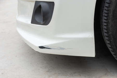 Close-up of crashed car's front area with cracks deep damage to the paintの写真素材