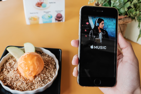 CHIANG MAI, THAILAND - JUL 26, 2016: A man hand holding screen shot of Apple music app showing on Iphone 6s. Apple Music is a beta version on ios.のeditorial素材