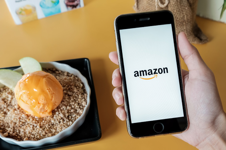 CHIANGMAI  - THAILAND  JAN 07, 2017: Amazon application on Apple iPhone 6s wich  cheese ice Cream on yellow table .Amazon is an American electronic e-commerce company distribution worlwideのeditorial素材