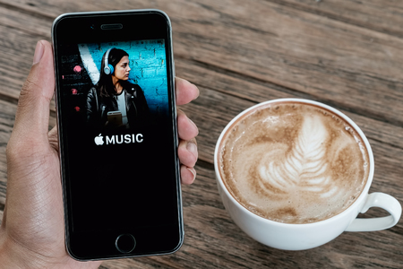 CHIANG MAI, THAILAND - JUL 26, 2016: A man hand holding screen shot of Apple music app showing on Iphone 6s. Apple Music is a beta version on ios.のeditorial素材