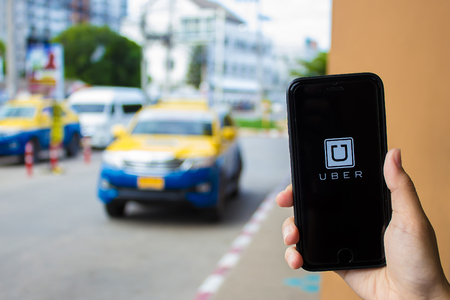CHIANG MAI,THAILAND - JUN 13,2016 : A MAN hand holding Uber app showing on iphone 6s. Uber is smartphone app-based transportation networkのeditorial素材