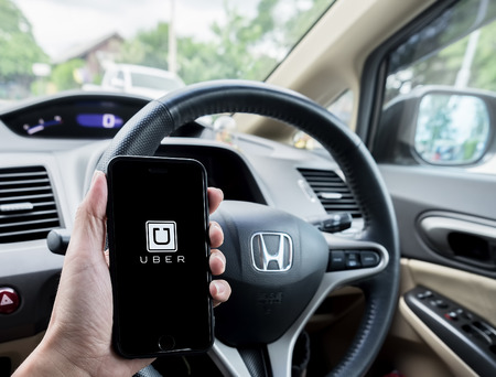 LAMPANG,THAILAND - JULY 13,2016 : A MAN hand holding Uber app showing on iphone 6s. Uber is smartphone app-based transportation networkのeditorial素材
