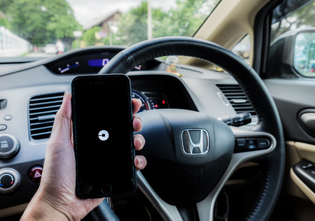 LAMPANG,THAILAND - JULY 13,2016 : A MAN hand holding Uber app showing on iphone 6s. Uber is smartphone app-based transportation networkのeditorial素材