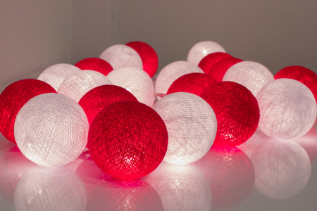 Red & White Cotton ball string lights. on the white desk.の写真素材