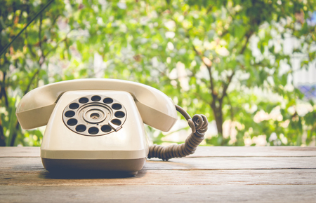 Retro rotary telephone on wood table vintage filterの写真素材