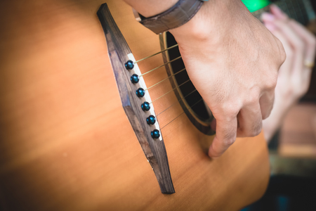 close up Man hand  playing acoustic guitar. vintage effect. release & relax concept.の写真素材