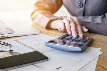 Business woman hand pointing calculator and using laptop computer for calculate stock maket chart of 
This month.の写真素材
