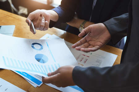 An auditor holds a pen pointing to documents to examine budgets and financial fraud.の写真素材