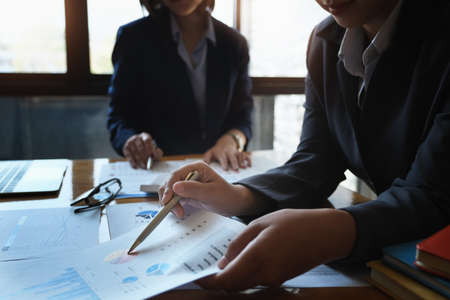 The company employee points to the document to calculate the budget and verify the correctness of the investment.の写真素材