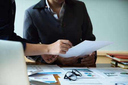The company employee points to the document to calculate the budget and verify the correctness of the investment.の写真素材