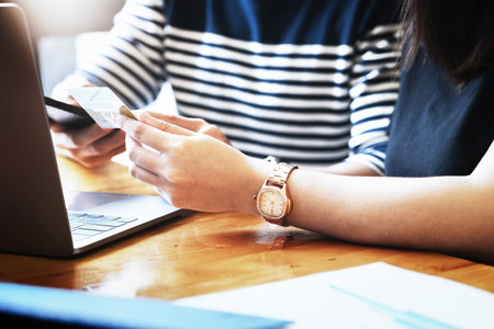 vintage tone with Give preference to female use credit cards while talking to men who are using computers for online shopping.の写真素材