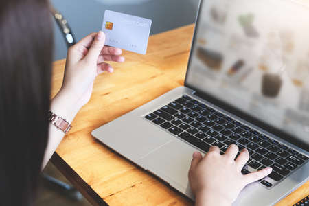 Online payment with Young Women hands holding credit card and using computer for online shoppingの写真素材