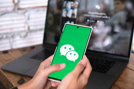 CHIANG MAI, THAILAND - June 06,2021:A Woman holds smartphone Mobile with WeChat app on the screen.WeChat is a Chinese multi-purpose messaging, social media and mobile payment app.のeditorial素材