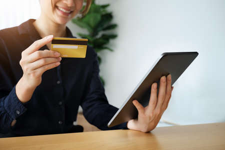 Online payment, Young Womens hands holding credit card and tablet for online shopping.