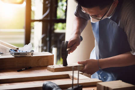 Entrepreneur Woodwork holding hammer to assemble the wood pieces as the customer orderedの写真素材