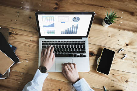 Business woman using computer to trade charts to find buy and sell points for her port.の写真素材