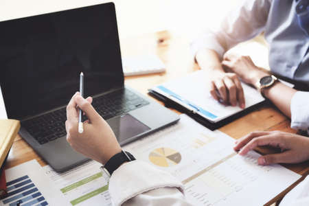 focus woman holding pen point laptop computer, A female business consultant describes a marketing...