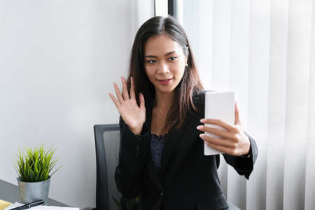 The young businesswoman is conference With people who work with use smartphoneの写真素材